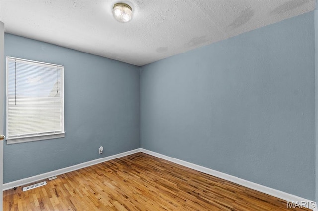 5748 State Highway 25, Cape Girardeau, MO 63701 - empty room with wood finished floors and a textured ceiling