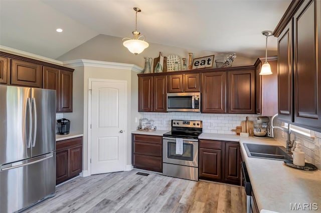 1209 Riesling Ln, Pevely, MO 63070 - kitchen featuring stainless steel appliances, light countertops, vaulted ceiling, decorative backsplash, and pendant lighting