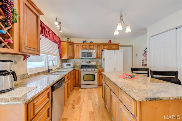 6 Barkwood Ct, Saint Peters, MO 63376 - kitchen featuring stainless steel appliances, light wood-style floors, a center island, decorative backsplash, and light stone counters