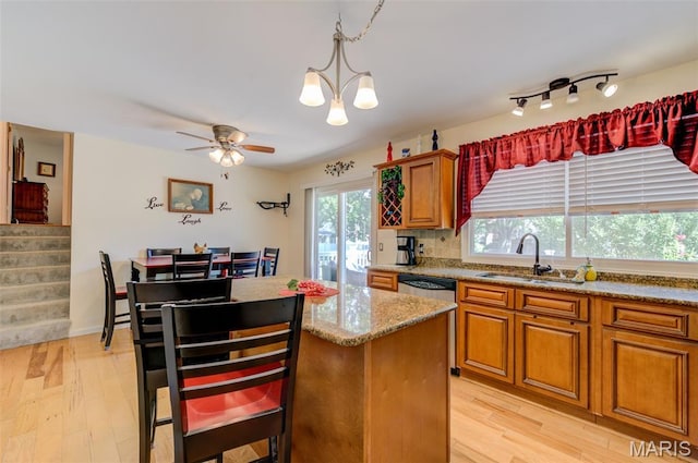 6 Barkwood Ct, Saint Peters, MO 63376 - kitchen featuring light wood-style floors, light stone counters, a center island, and brown cabinetry