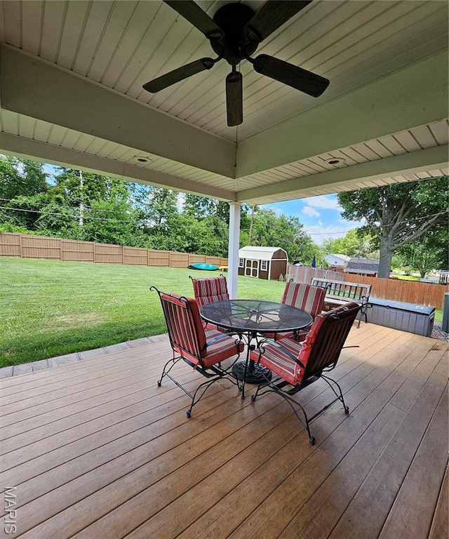 22 Settlers Trl, Hannibal, MO 63401 - wooden deck with outdoor dining space, a storage unit, a ceiling fan, and a fenced backyard