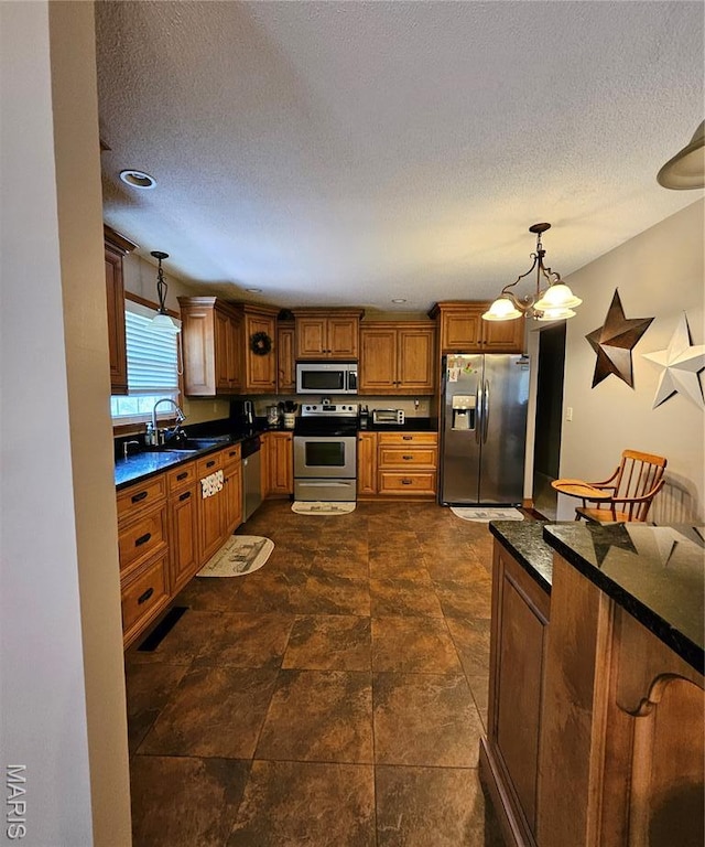 22 Settlers Trl, Hannibal, MO 63401 - kitchen featuring appliances with stainless steel finishes, dark countertops, brown cabinets, hanging light fixtures, and a chandelier