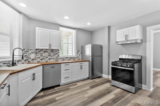 207 N 13th St, Belleville, IL 62220 - kitchen featuring stainless steel appliances, under cabinet range hood, wood counters, white cabinetry, and recessed lighting