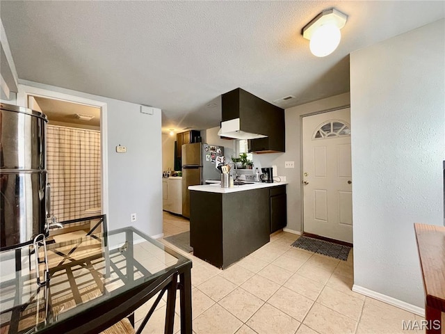 100A Wall St, New Haven, MO 63068 - kitchen with a peninsula, light countertops, freestanding refrigerator, a textured ceiling, and light tile patterned floors