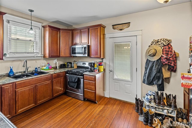505 Sycamore St, Belleville, IL 62220 - kitchen with stainless steel appliances, wood-type flooring, hanging light fixtures, brown cabinetry, and light stone counters