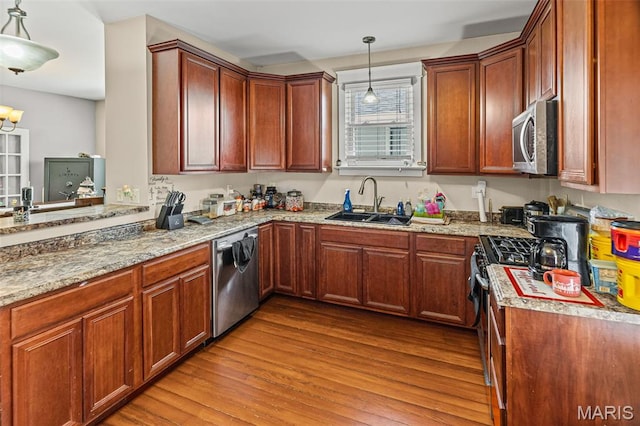 505 Sycamore St, Belleville, IL 62220 - kitchen featuring stainless steel appliances, wood finished floors, light stone countertops, hanging light fixtures, and brown cabinetry