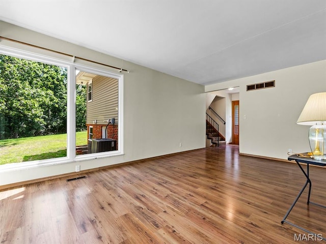 4488 Rock Creek Valley Rd, House Springs, MO 63051 - unfurnished living room featuring healthy amount of natural light, wood finished floors, and stairway