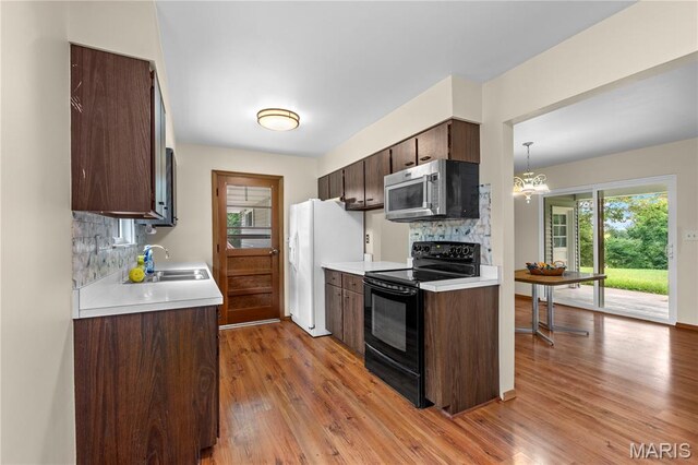 4488 Rock Creek Valley Rd, House Springs, MO 63051 - kitchen with stainless steel microwave, electric range, white fridge with ice dispenser, and tasteful backsplash