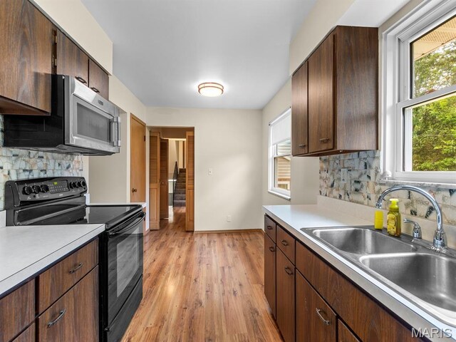 4488 Rock Creek Valley Rd, House Springs, MO 63051 - kitchen with electric range, stainless steel microwave, light wood-type flooring, light countertops, and tasteful backsplash
