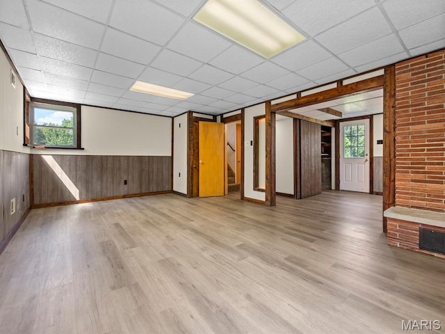 4488 Rock Creek Valley Rd, House Springs, MO 63051 - unfurnished room featuring a drop ceiling, plenty of natural light, light wood-style flooring, stairs, and wainscoting