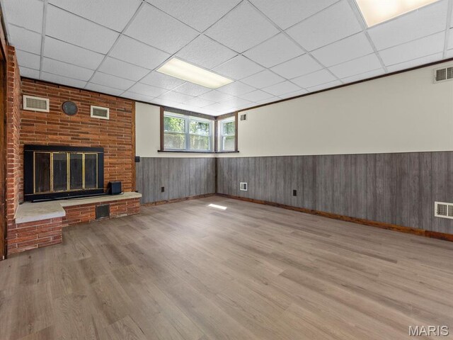 4488 Rock Creek Valley Rd, House Springs, MO 63051 - unfurnished living room featuring a paneled ceiling, wood finished floors, wainscoting, and a fireplace