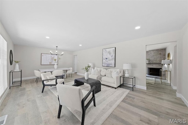 6781 Lesli Mari Ct, Florissant, MO 63033 - living room featuring light wood-style flooring, a chandelier, recessed lighting, and a fireplace