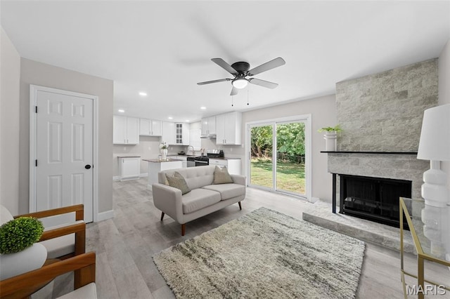 6781 Lesli Mari Ct, Florissant, MO 63033 - living area featuring a ceiling fan, a fireplace, light wood finished floors, and recessed lighting