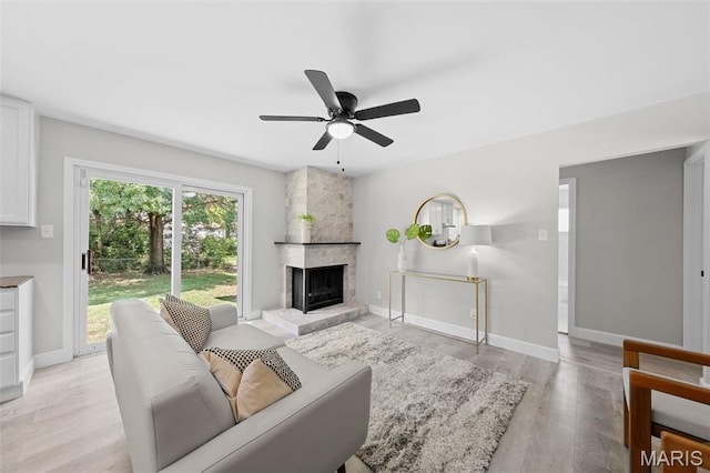 6781 Lesli Mari Ct, Florissant, MO 63033 - living room featuring a ceiling fan, light wood-style floors, and a fireplace
