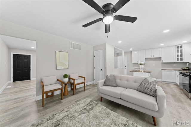 6781 Lesli Mari Ct, Florissant, MO 63033 - living room featuring light wood-style flooring, ceiling fan, and recessed lighting