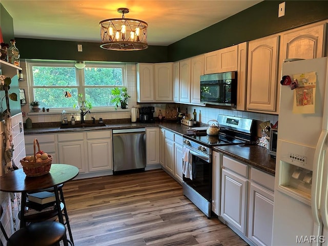 8705 State Road Y, Dittmer, MO 63023 - kitchen featuring stainless steel appliances, dark countertops, wood finished floors, and backsplash