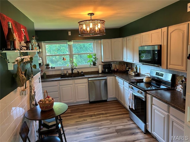 8705 State Road Y, Dittmer, MO 63023 - kitchen featuring appliances with stainless steel finishes, dark countertops, a chandelier, backsplash, and wood finished floors