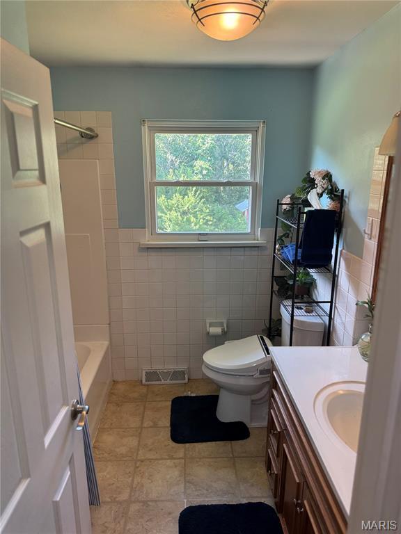 8705 State Road Y, Dittmer, MO 63023 - bathroom with tile walls, vanity, tile patterned floors, bathtub / shower combination, and wainscoting