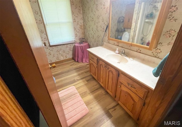402 N Viola St, Bloomfield, MO 63825 - bathroom with wallpapered walls, wood finished floors, and vanity