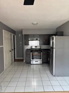 2623 Hord Ave, Jennings, MO 63136 - kitchen with freestanding refrigerator, stainless steel range with electric cooktop, light tile patterned floors, and exhaust hood