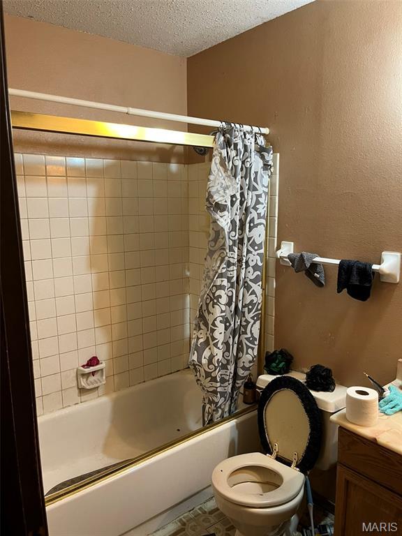 2345 Derhake Rd, Florissant, MO 63033 - full bathroom featuring shower / bathtub combination with curtain, a textured ceiling, and vanity