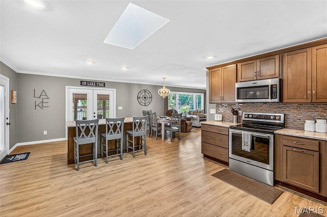 11178 Catatoga Dr, Plainview, IL 62685 - kitchen with appliances with stainless steel finishes, a kitchen bar, crown molding, decorative backsplash, and light wood finished floors