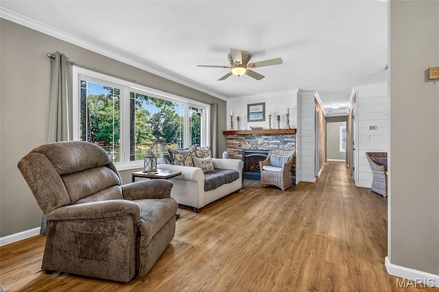 11178 Catatoga Dr, Plainview, IL 62685 - living room featuring a ceiling fan, ornamental molding, light wood-style flooring, and a stone fireplace