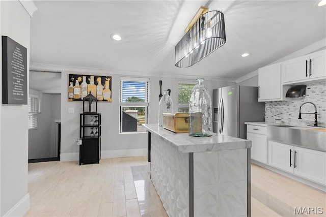 1821 Edwardsville Rd, Madison, IL 62060 - kitchen featuring stainless steel fridge with ice dispenser, decorative backsplash, a center island, white cabinets, and light wood-style flooring