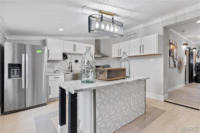 1821 Edwardsville Rd, Madison, IL 62060 - kitchen featuring stainless steel fridge with ice dispenser, wall chimney range hood, crown molding, decorative backsplash, and white cabinets