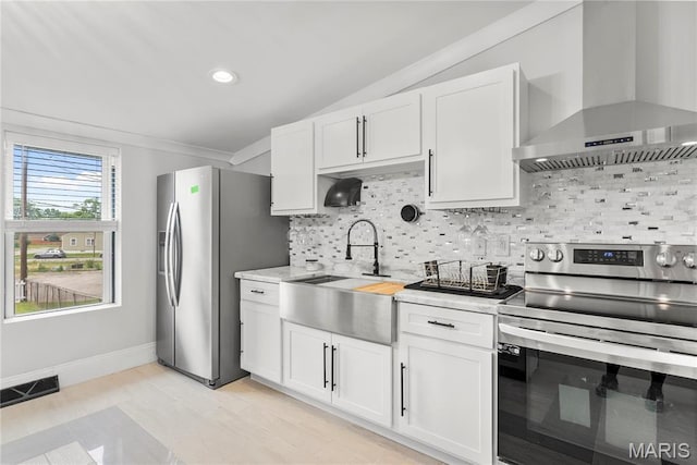 1821 Edwardsville Rd, Madison, IL 62060 - kitchen with wall chimney exhaust hood, stainless steel appliances, backsplash, white cabinets, and recessed lighting