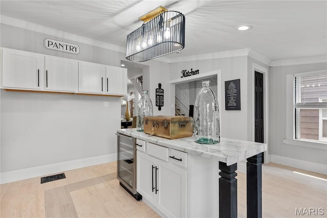 1821 Edwardsville Rd, Madison, IL 62060 - kitchen featuring wine cooler, white cabinets, recessed lighting, a kitchen island, and decorative light fixtures