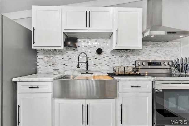 1821 Edwardsville Rd, Madison, IL 62060 - kitchen featuring wall chimney exhaust hood, stainless steel appliances, tasteful backsplash, white cabinetry, and light stone countertops