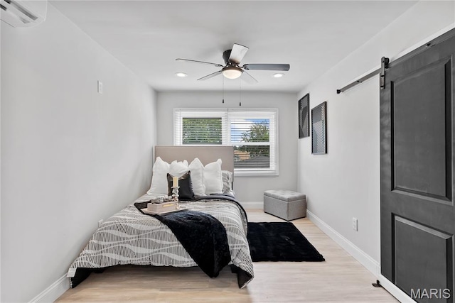 1821 Edwardsville Rd, Madison, IL 62060 - bedroom with a barn door, wood finished floors, an AC wall unit, recessed lighting, and ceiling fan