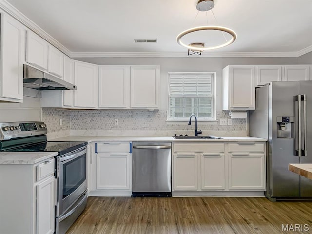 240 Brookmont Dr, Belleville, IL 62221 - kitchen featuring appliances with stainless steel finishes, under cabinet range hood, light countertops, white cabinets, and ornamental molding