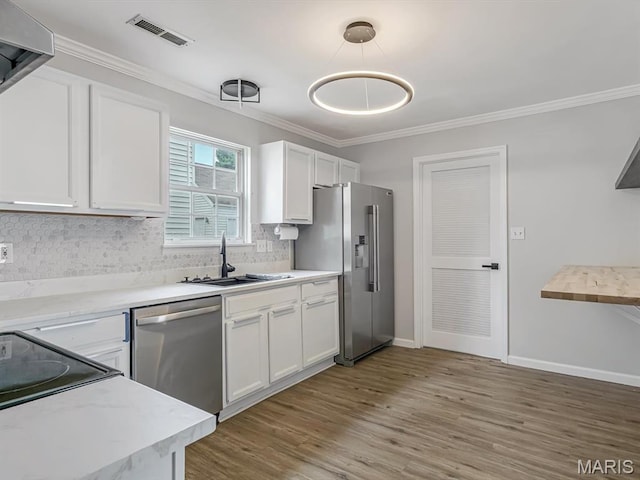 240 Brookmont Dr, Belleville, IL 62221 - kitchen with appliances with stainless steel finishes, white cabinets, tasteful backsplash, wood finished floors, and crown molding