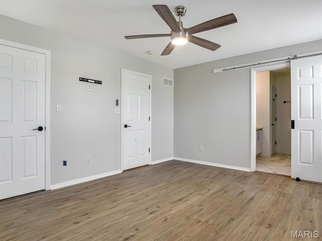 240 Brookmont Dr, Belleville, IL 62221 - unfurnished bedroom with wood finished floors, a ceiling fan, and connected bathroom