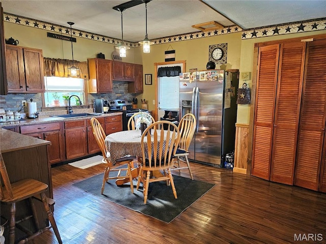 521 Cherry St, Tilden, IL 62292 - kitchen featuring appliances with stainless steel finishes, backsplash, decorative light fixtures, dark wood-style flooring, and brown cabinets