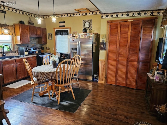 521 Cherry St, Tilden, IL 62292 - kitchen with appliances with stainless steel finishes, dark wood-style floors, decorative backsplash, and hanging light fixtures