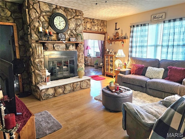 521 Cherry St, Tilden, IL 62292 - living room featuring a textured ceiling, a stone fireplace, and wood finished floors
