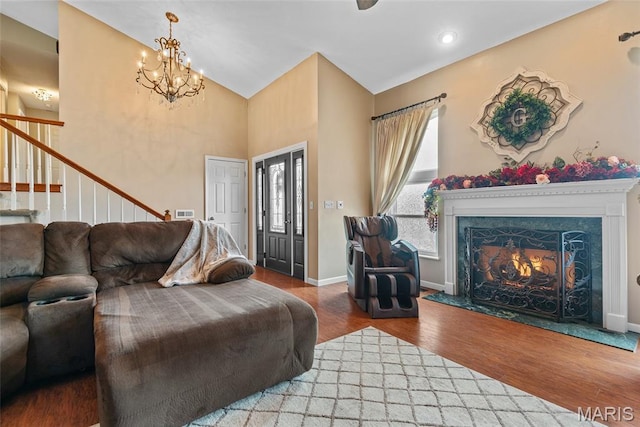 34 Windermere Dr, Glen Carbon, IL 62034 - living room featuring wood finished floors, stairway, a chandelier, high vaulted ceiling, and a premium fireplace