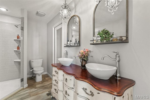 34 Windermere Dr, Glen Carbon, IL 62034 - bathroom featuring a shower stall, double vanity, a chandelier, and wood finished floors