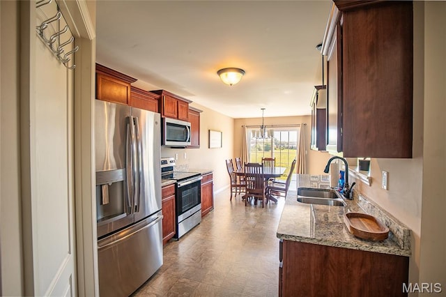 27492 Forest Ridge Ct, Warrenton, MO 63383 - kitchen featuring stainless steel appliances, stone countertops, dark floors, and pendant lighting