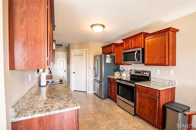 27492 Forest Ridge Ct, Warrenton, MO 63383 - kitchen featuring appliances with stainless steel finishes, light stone counters, and brown cabinetry