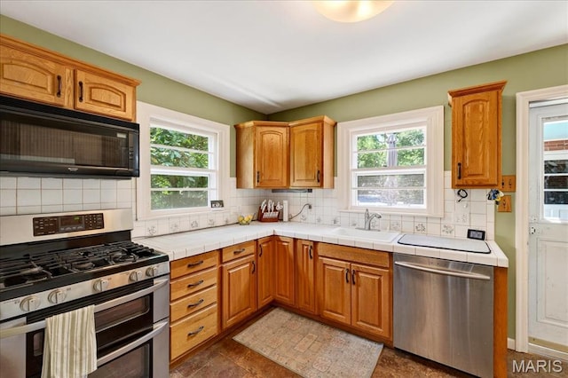 8548 Big Bend Blvd, Webster Groves, MO 63119 - kitchen with appliances with stainless steel finishes, plenty of natural light, tasteful backsplash, and tile countertops