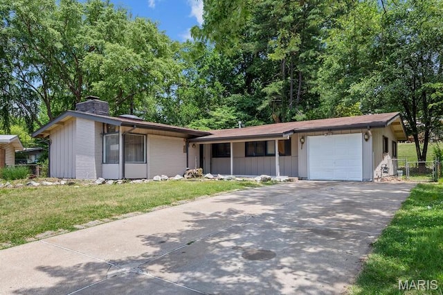 12 Country Ln, Florissant, MO 63033 - view of front of home featuring a chimney, concrete driveway, an attached garage, covered porch, and board and batten siding