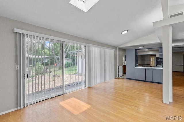 12 Country Ln, Florissant, MO 63033 - unfurnished living room with light wood finished floors, lofted ceiling, and a skylight