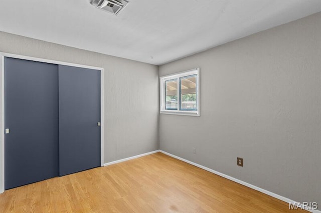 12 Country Ln, Florissant, MO 63033 - unfurnished bedroom with light wood-type flooring and a closet
