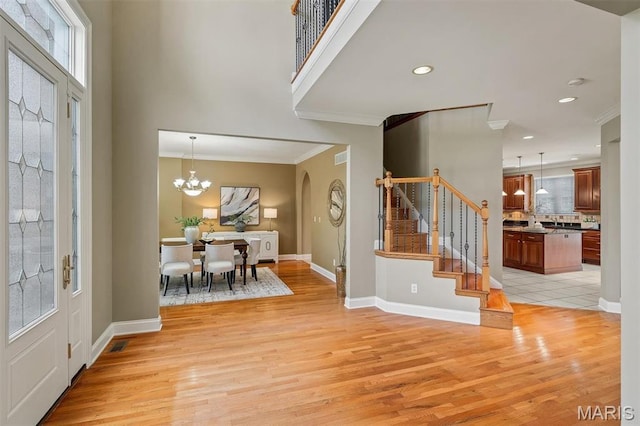 1011 Hawks Landing Dr, Lake St Louis, MO 63367 - entryway with stairs, light wood finished floors, plenty of natural light, crown molding, and a chandelier