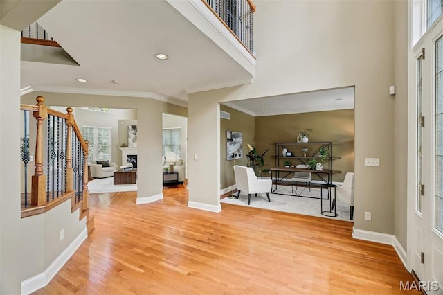 1011 Hawks Landing Dr, Lake St Louis, MO 63367 - entryway featuring plenty of natural light, ornamental molding, light wood-type flooring, a fireplace, and recessed lighting