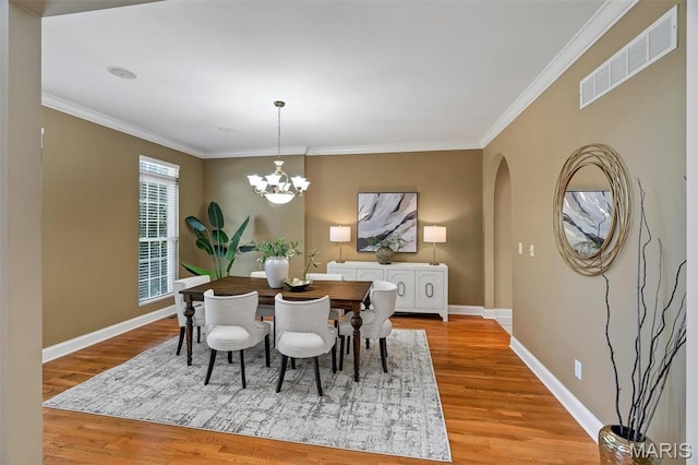 1011 Hawks Landing Dr, Lake St Louis, MO 63367 - dining area featuring wood finished floors, arched walkways, a chandelier, and crown molding